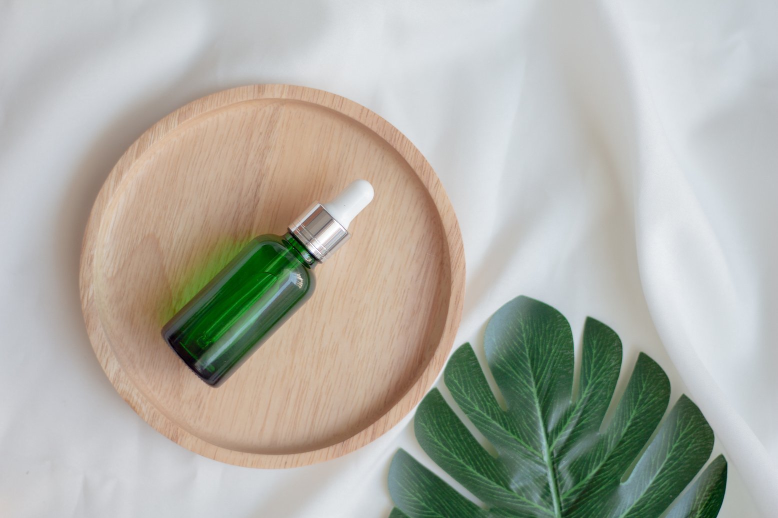 Green Dropper Bottle Serum on Wood Plate